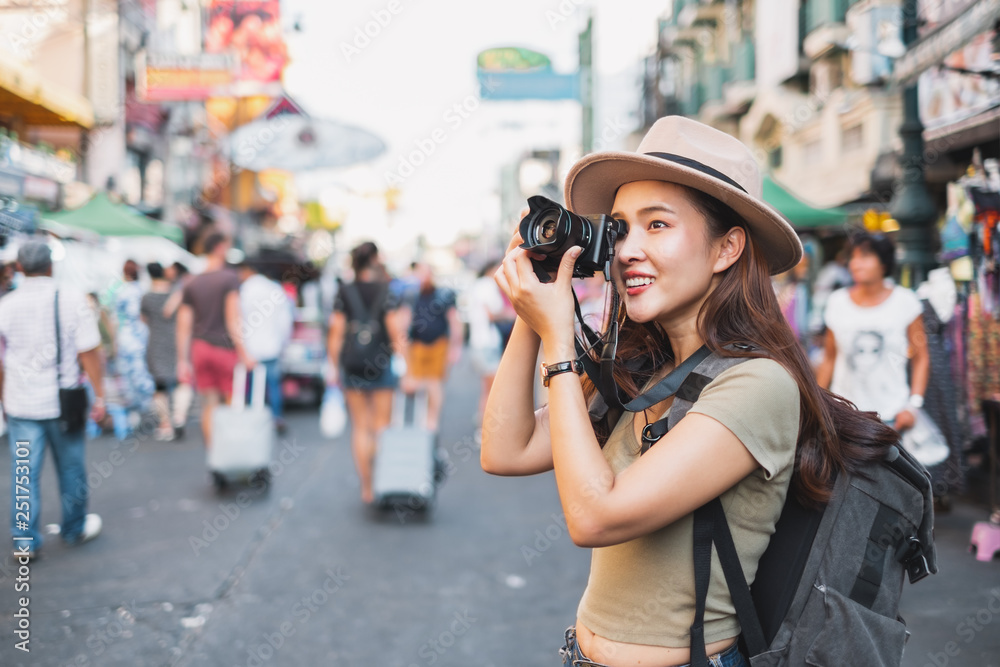 Asian woman tourist backpacker travel and taking photo in Khao San road, Bangkok, Thailand