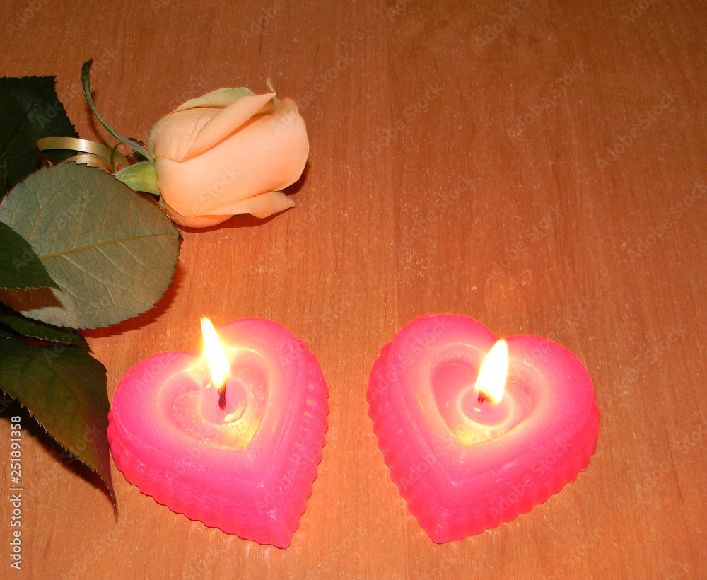 rose two burning candles in the shape of a heart 