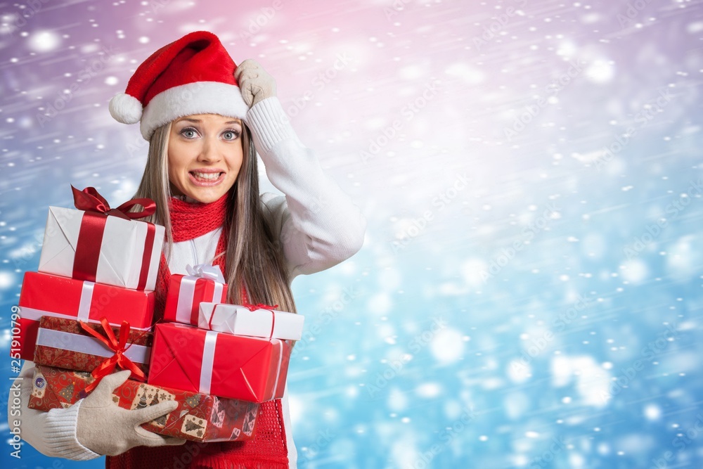 Beautiful blonde woman in Santa hat with gifts