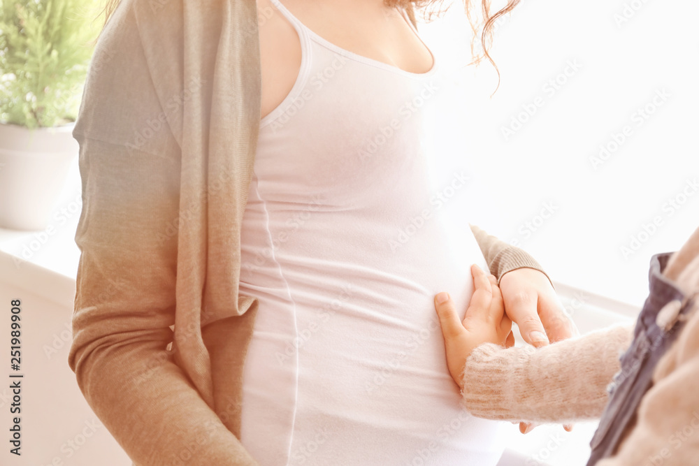 Little girl with pregnant mother at home