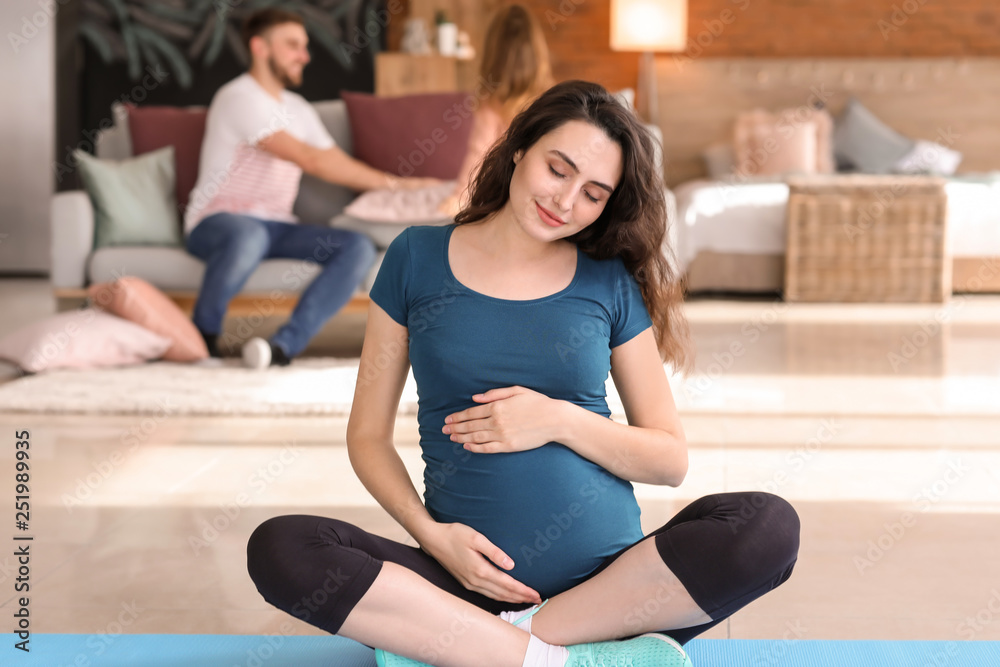 Pregnant woman doing yoga at home