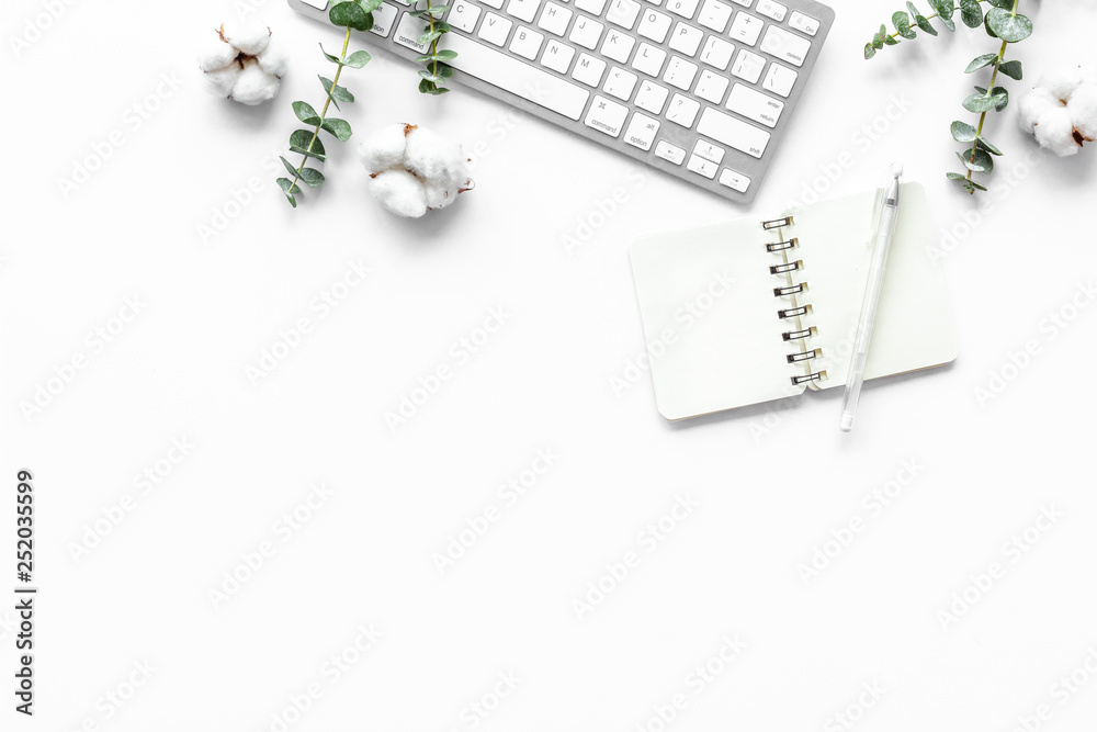 Laptop, cotton branch on white table flat lay copy space. Minimal freelancer home office desk worksp