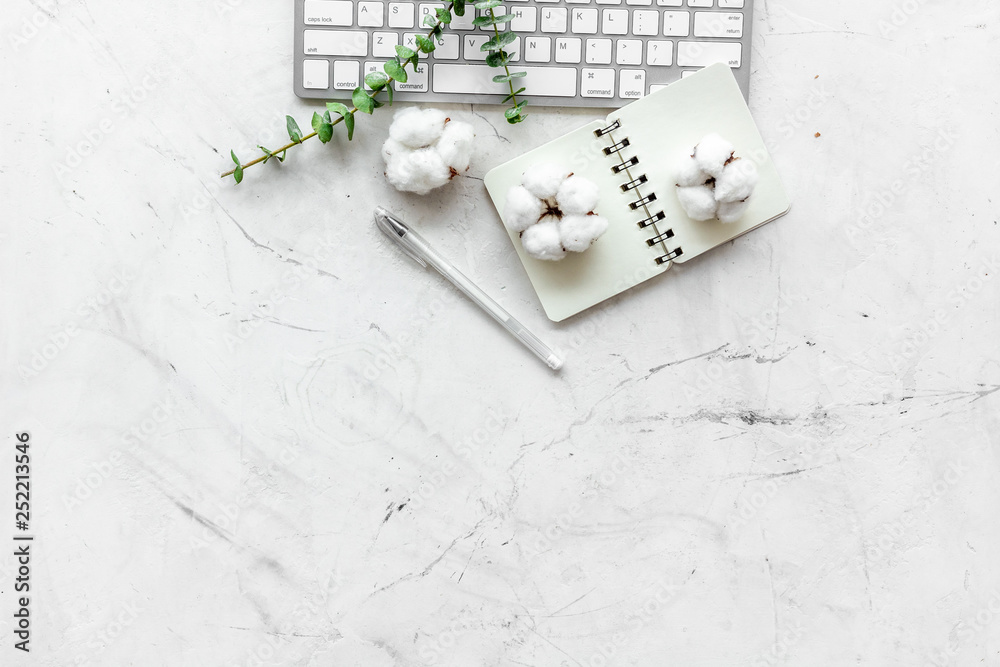 Laptop, cotton branch, notebook on white background flat lay copy space. Minimal freelancer home off