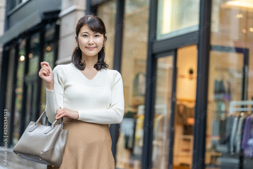 年轻的亚洲女人走在购物街上