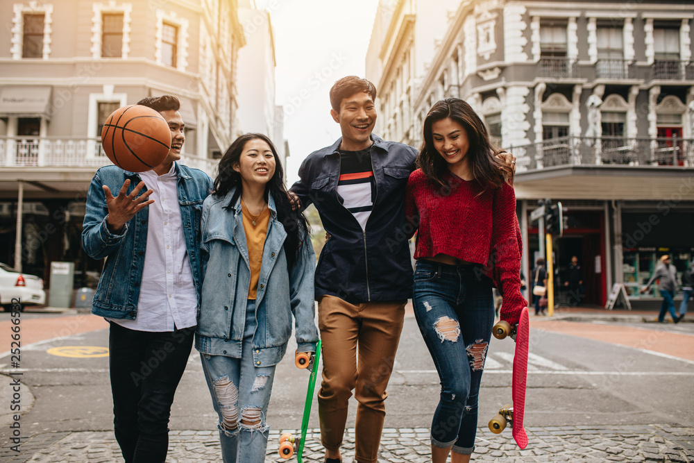 Four friends walking on city street