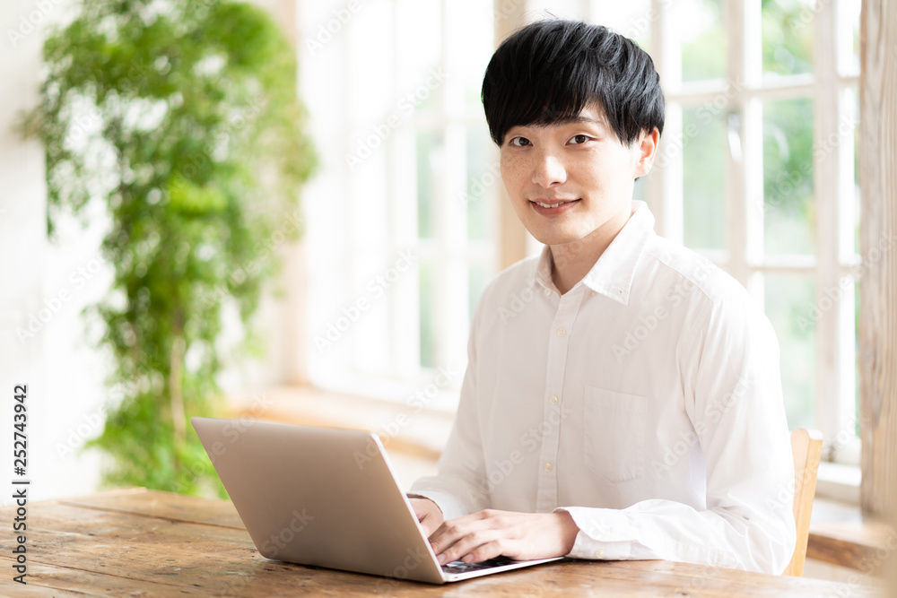 young asian man using laptop in living room