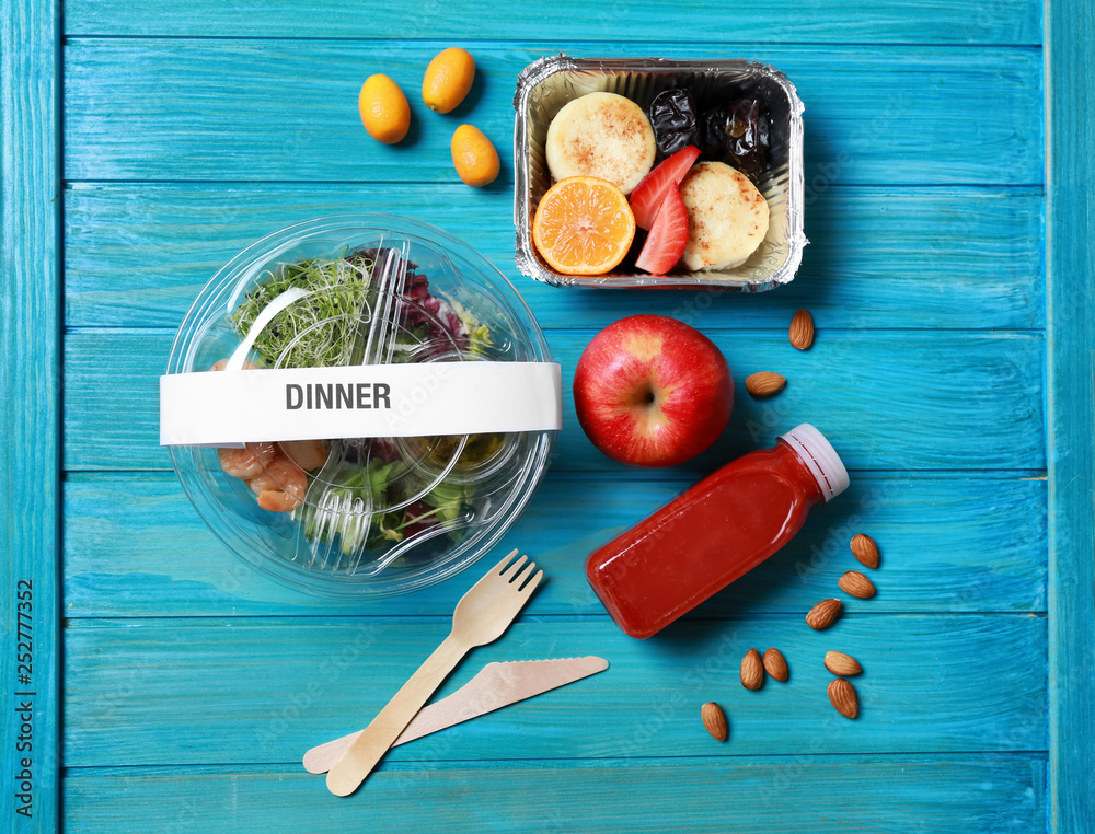 Containers with delicious food on wooden background