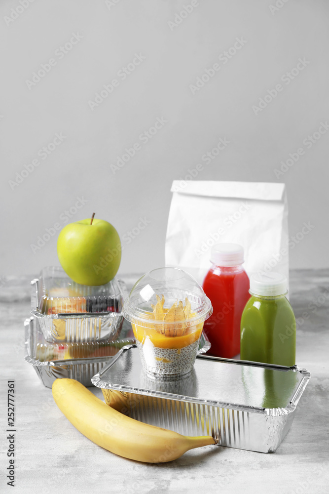 Containers with delicious food on table