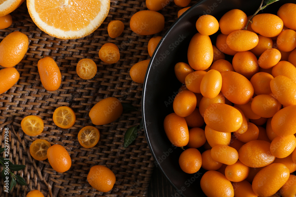 Plate with delicious kumquat fruit on table