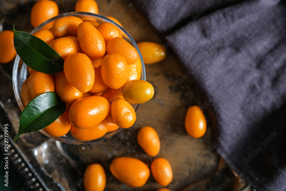 Dessert bowl with delicious kumquat fruit on metal tray