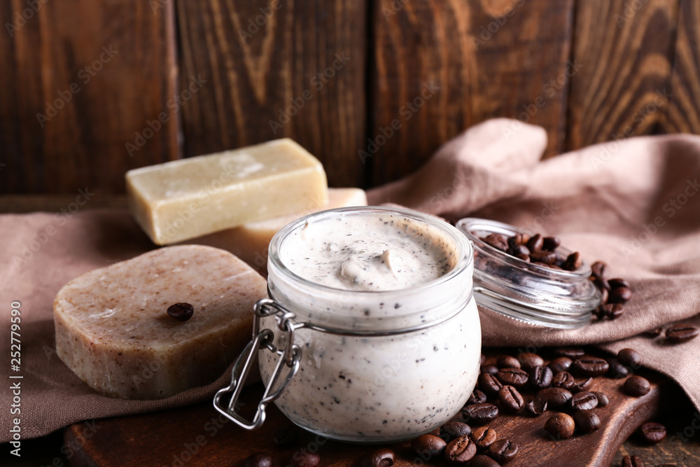 Jar with natural scrub and soap on table