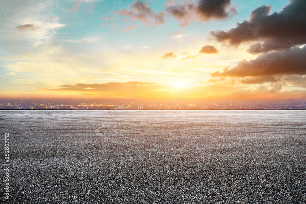 Empty asphalt square ground and city skyline with beautiful clouds at sunset