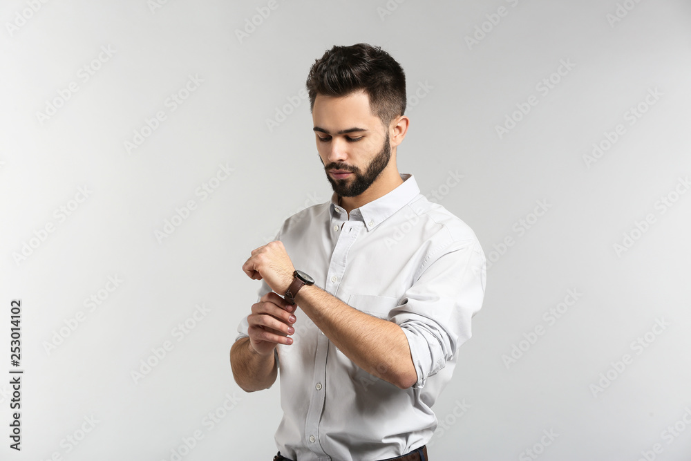 Fashionable young man on light background