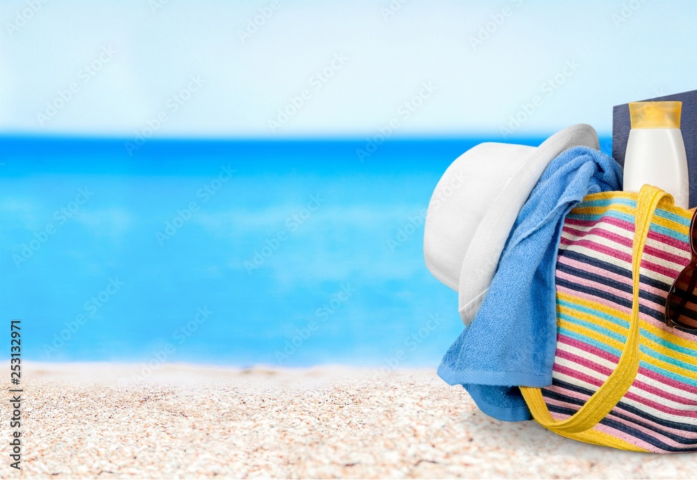 Bag with flip flops on beach