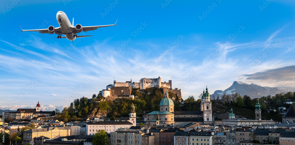 Landscape scene of Fortress Hohensalzburg of Salzburg with Salzach river line with airplane fly abov