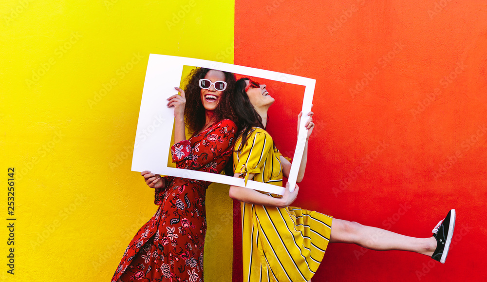 Smiling women with empty photo frame