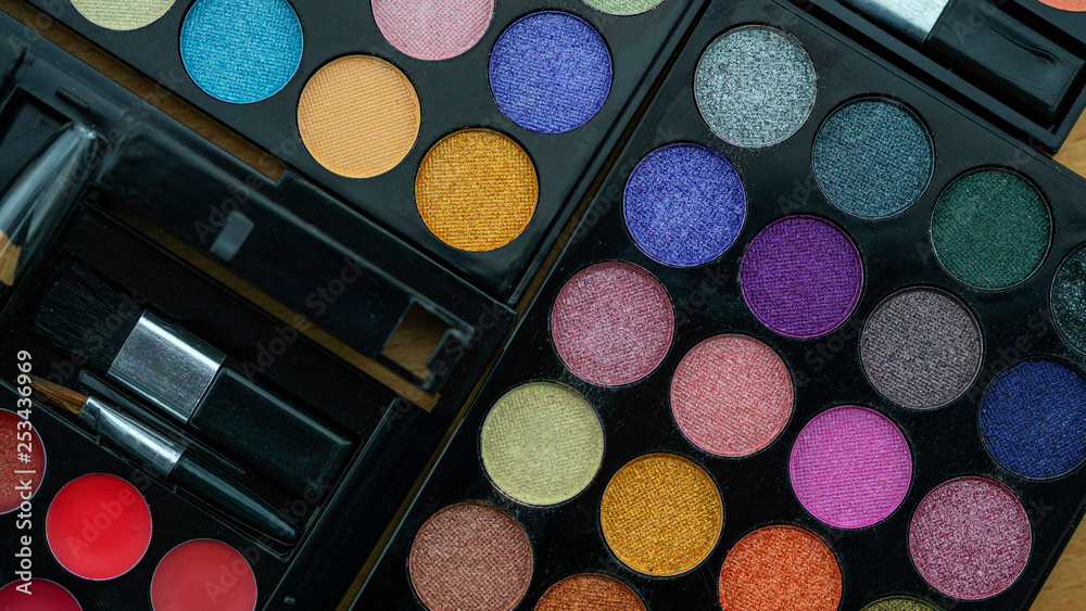 Flat lay photo of various makeup brush, eyeshadow and cosmetics