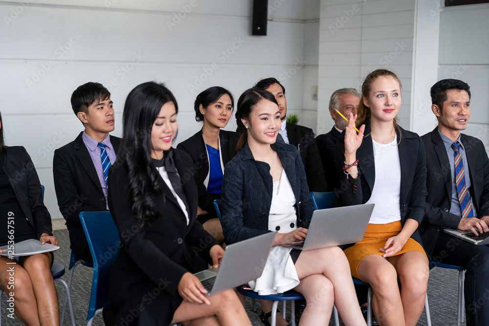 Young Asian and Caucasian audience sitting and listen to speaker in group meeting presentation at th