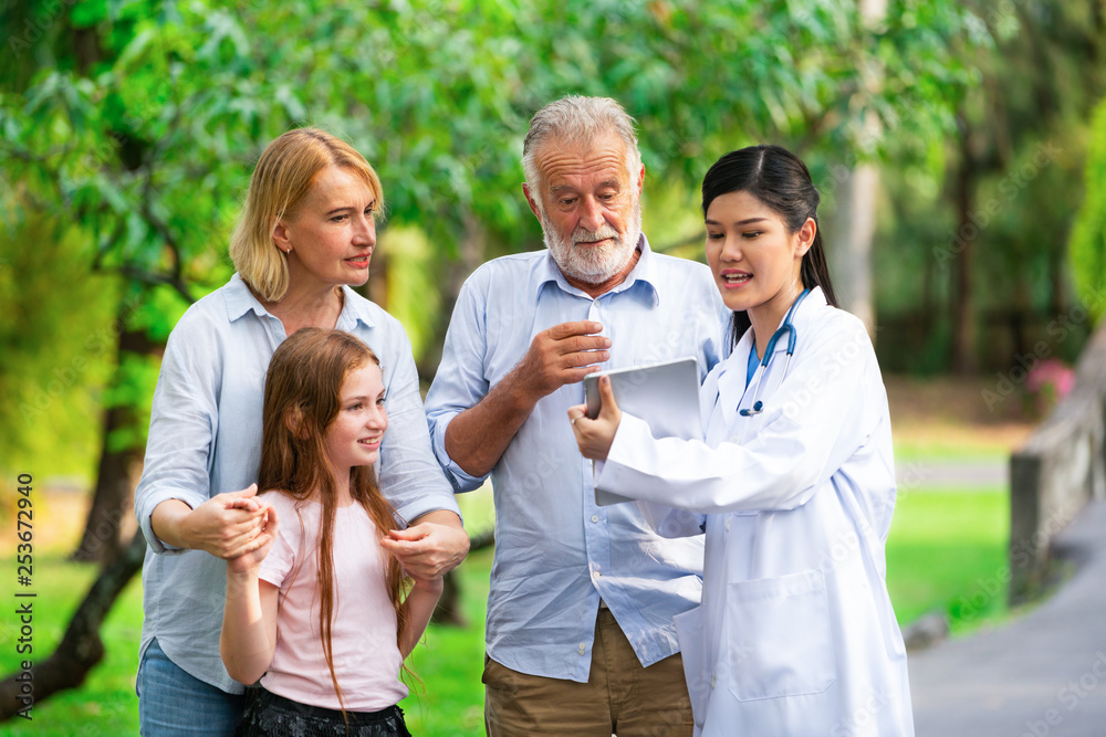 Happy healthy family and doctor talking in the park. People healthcare and medical staff service con