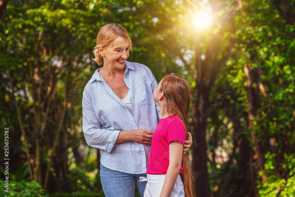 Relaxed happy mother and little kid daughter in outdoors public park. Parenthood and child concept.