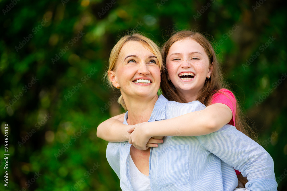 Relaxed happy mother and little kid daughter in outdoors public park. Parenthood and child concept.