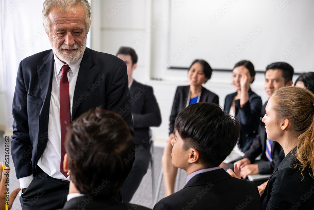 Senior leader speaker speaks to public people audience in training workshop or conference. Mature le