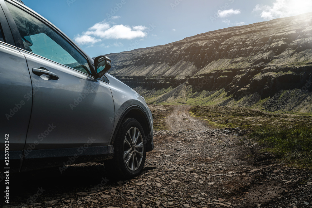 4WD SUV vehicle car running on gravel road with nature mountain landscape in Iceland. Adventure and 