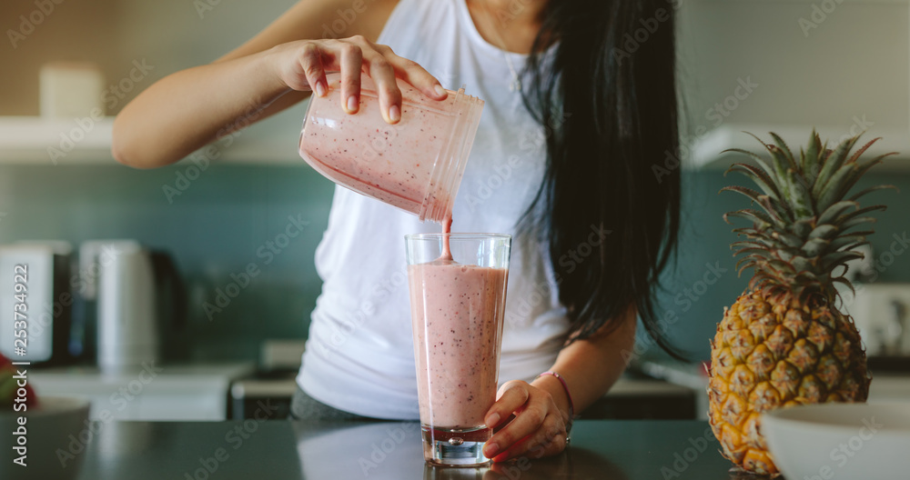 Woman preparing fresh fruit smoothie