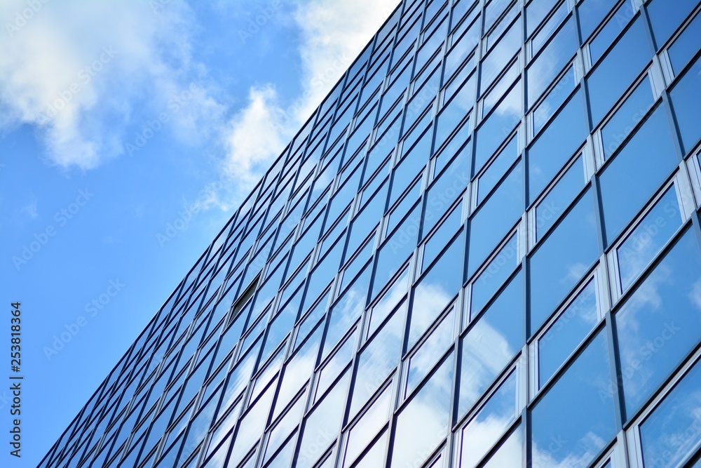 Surface of glass building with the reflection of clouds