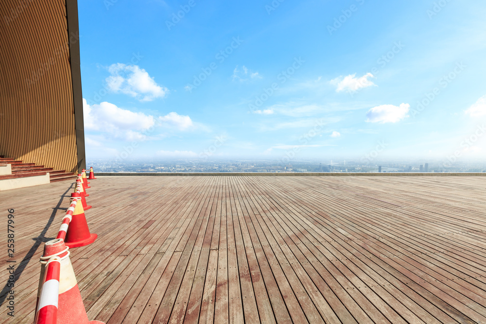 Empty wooden board square and modern city skyline with beautiful clouds