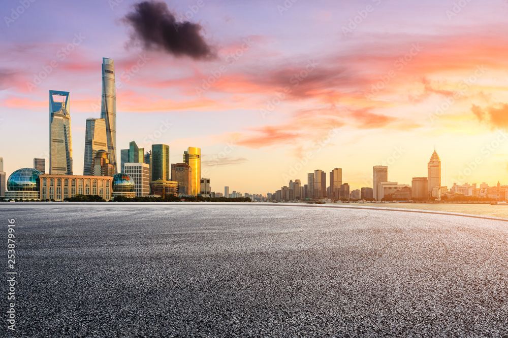 Empty asphalt road through Shanghai business district at sunset