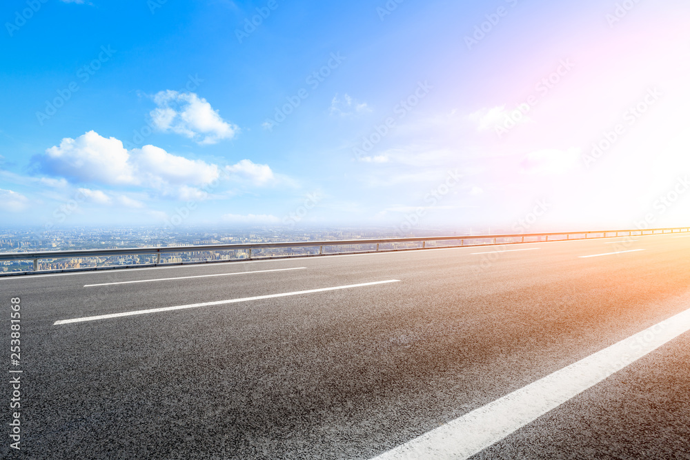 Asphalt highway passing above modern city