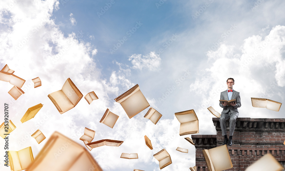 Young businessman or student studying the science and books flying around