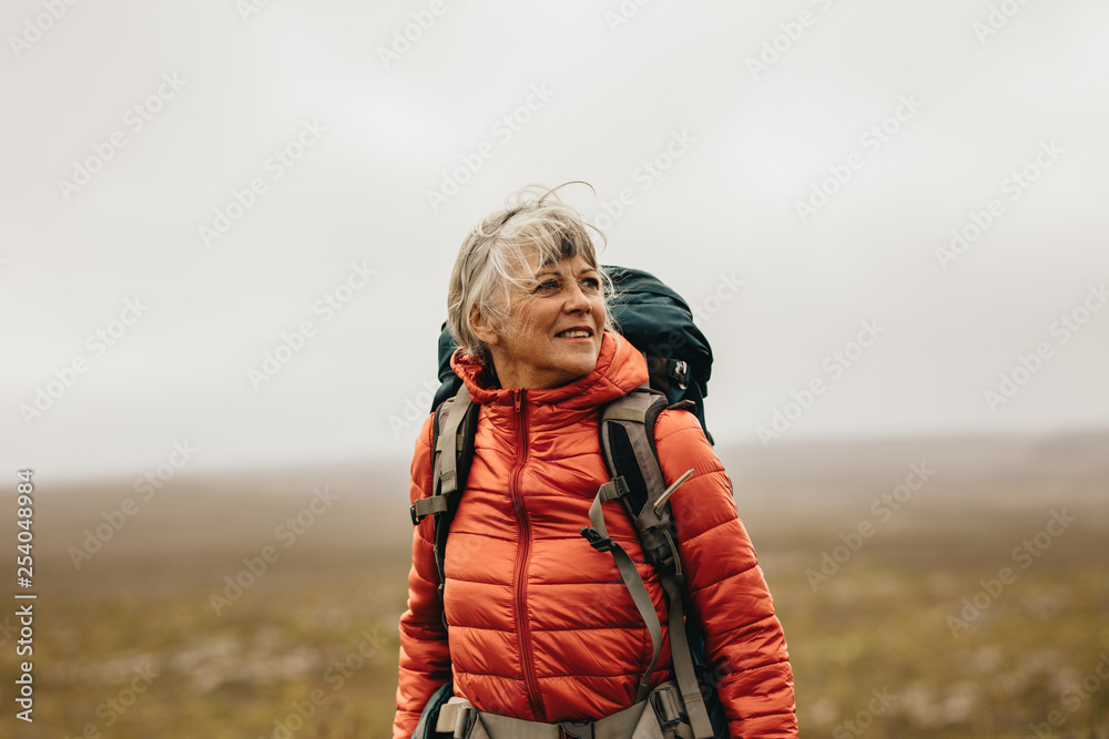 Female hiker enjoying the view standing on a hill