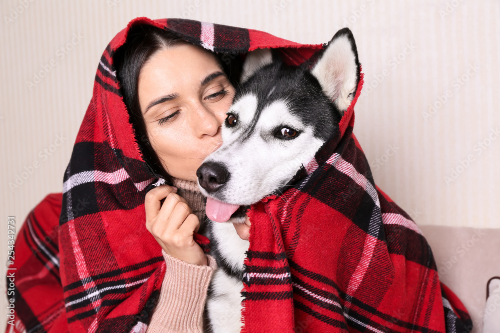 Portrait of young woman with her cute husky dog at home