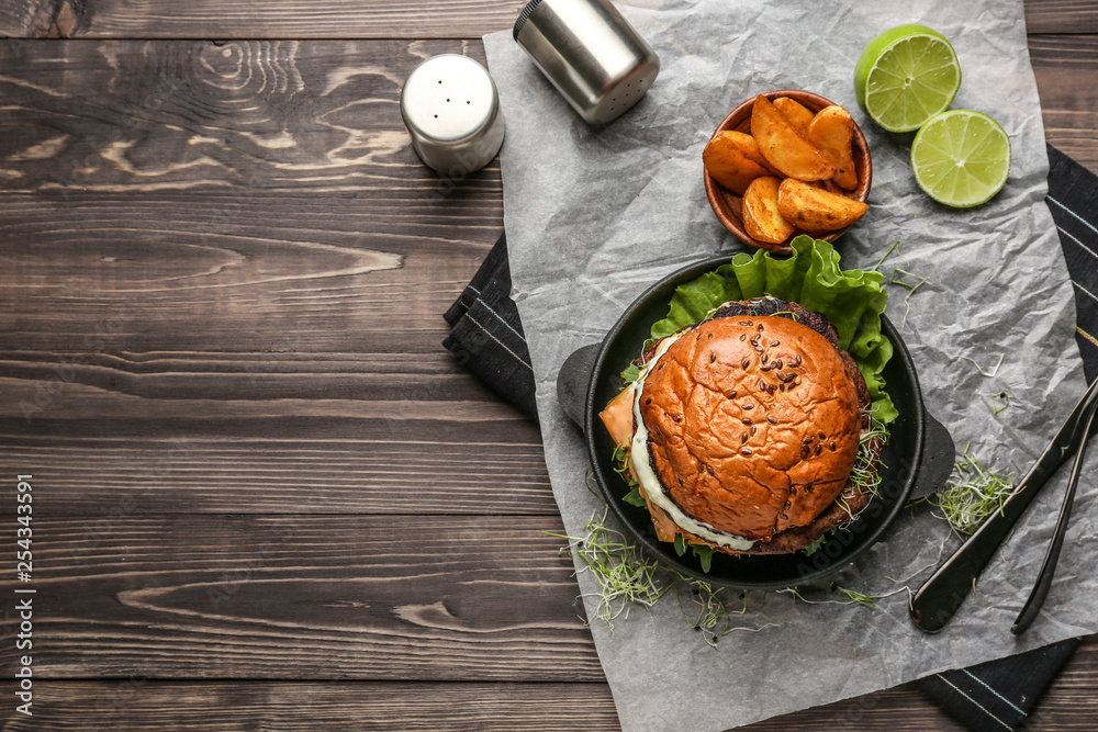 Composition with tasty burger on table