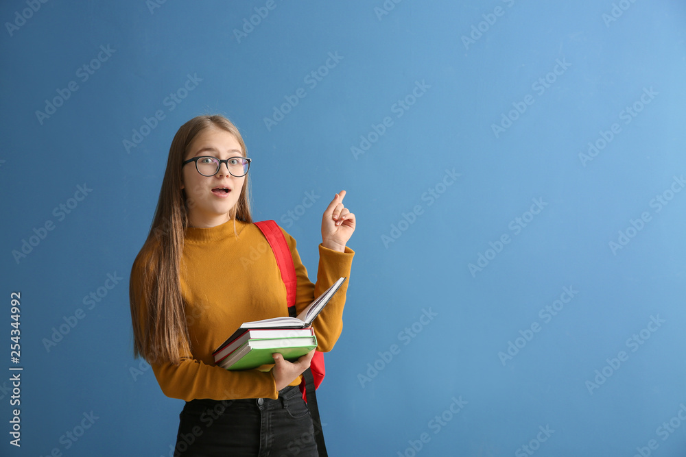 女学生拿着书，在彩色背景上竖起食指