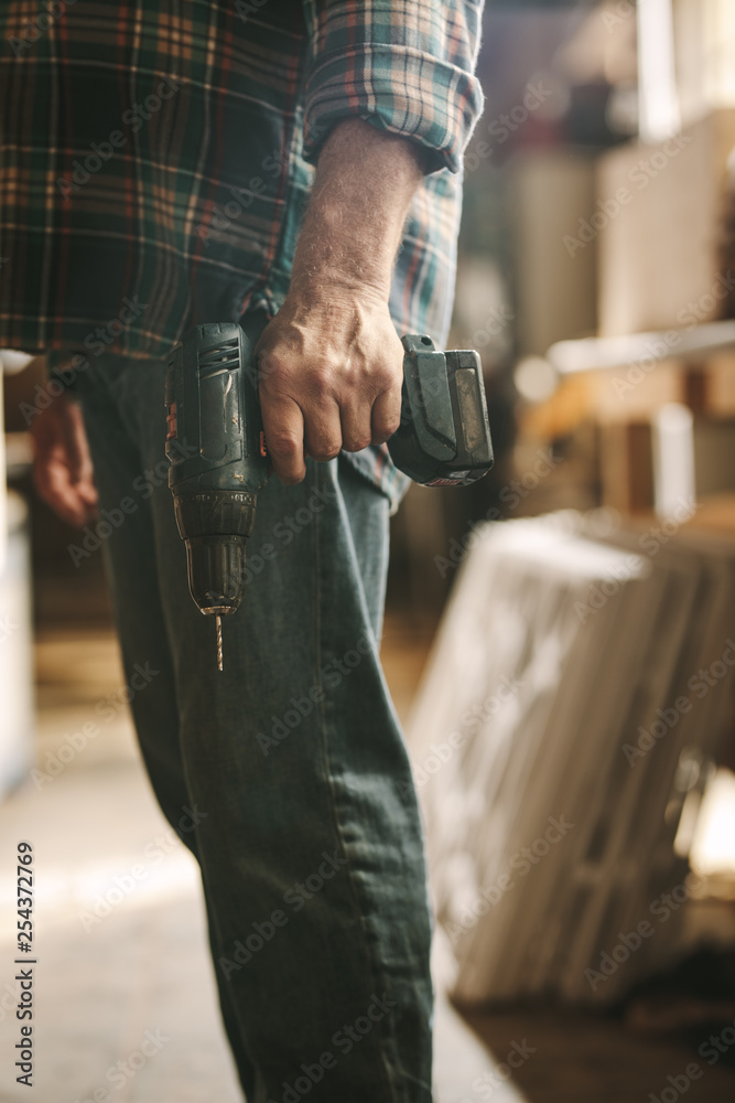 Carpenter with a hand drill machine