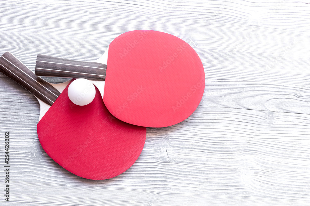 Red racket for ping pong ball wooden background top view