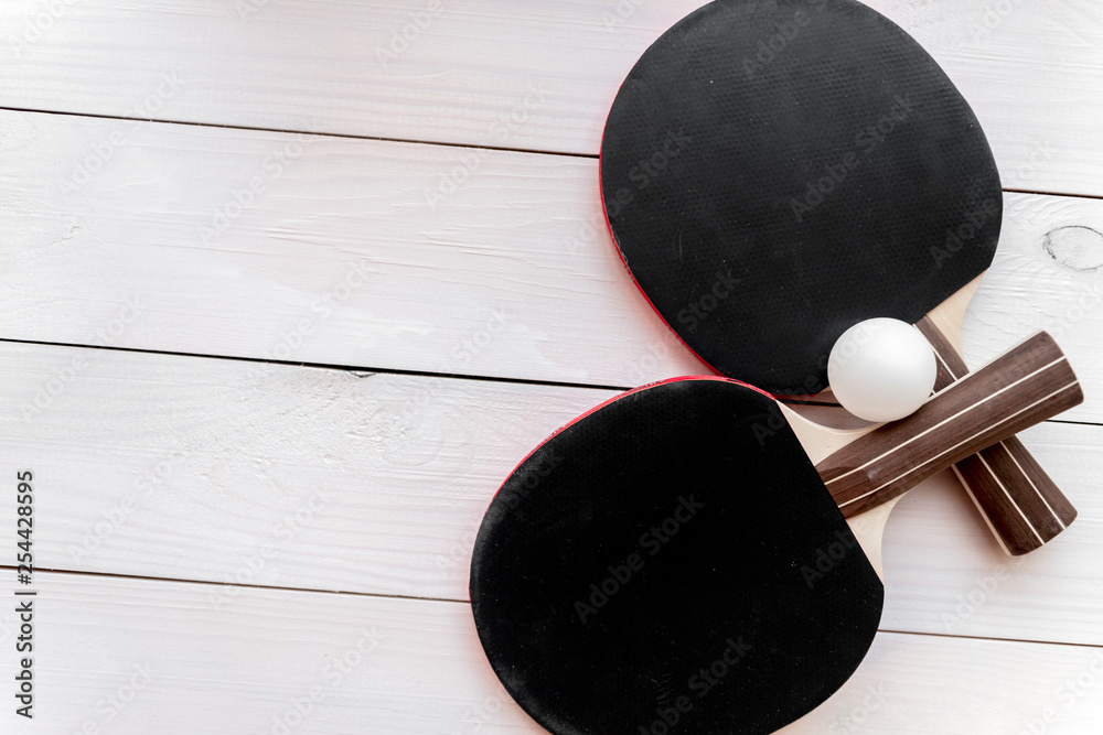 black racket for ping pong ball wooden background top view