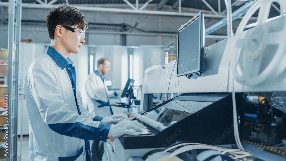 On High Tech Factory Asian Engineer Uses Computer for Programing Pick and Place Electronic Machinery