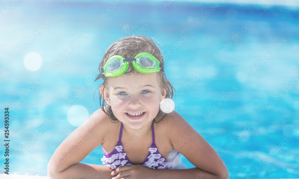 Beautiful little girl swimming at the pool