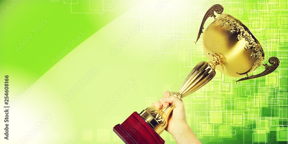 Hand holding golden Trophy on bokeh background