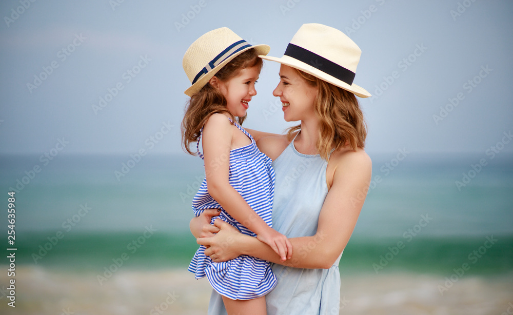 happy family at beach. mother and child daughter hug at sea.