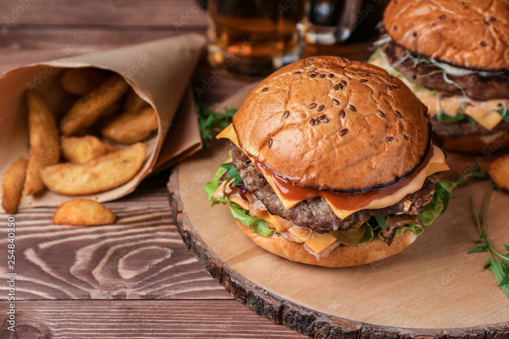 Tasty burgers and fried potato on table