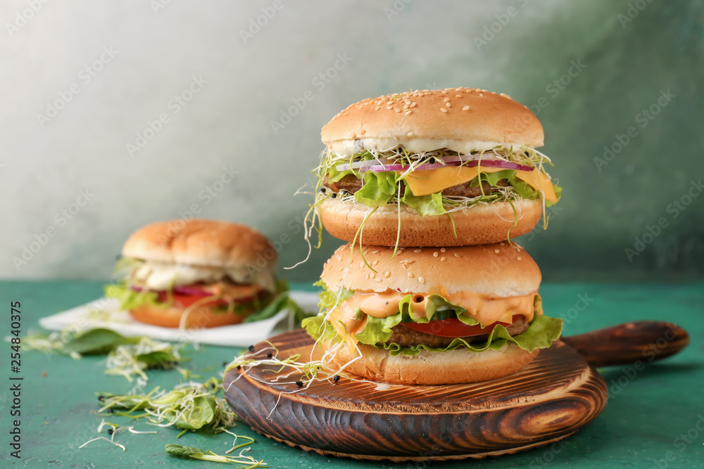 Stack of tasty burgers on table