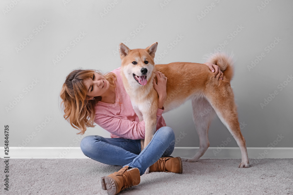 灯光墙附近有一只可爱的秋田犬的女人