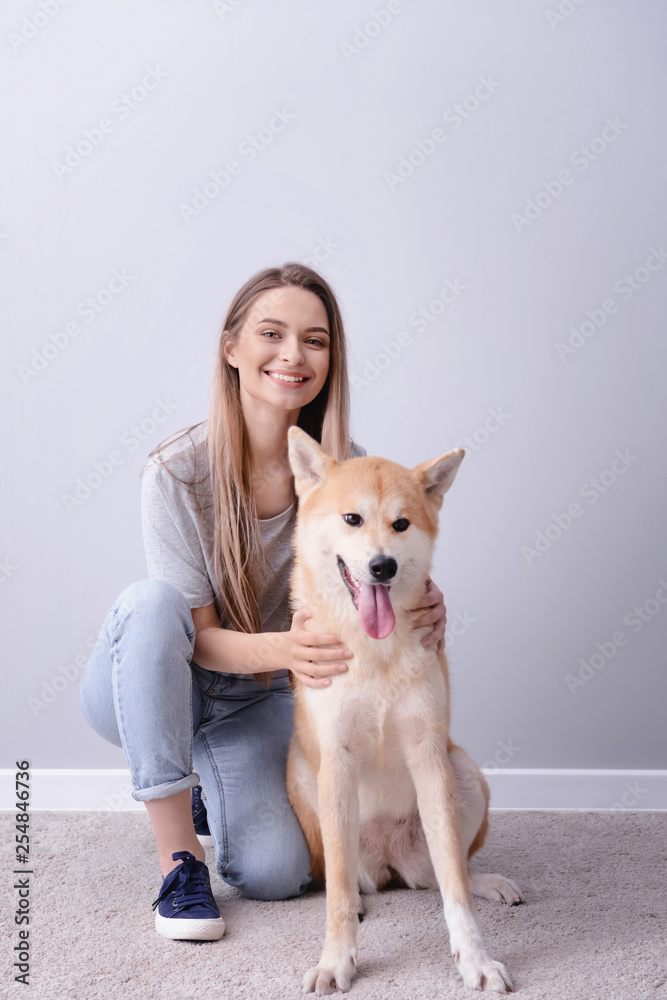 光墙附近有一只可爱的秋田犬的女人