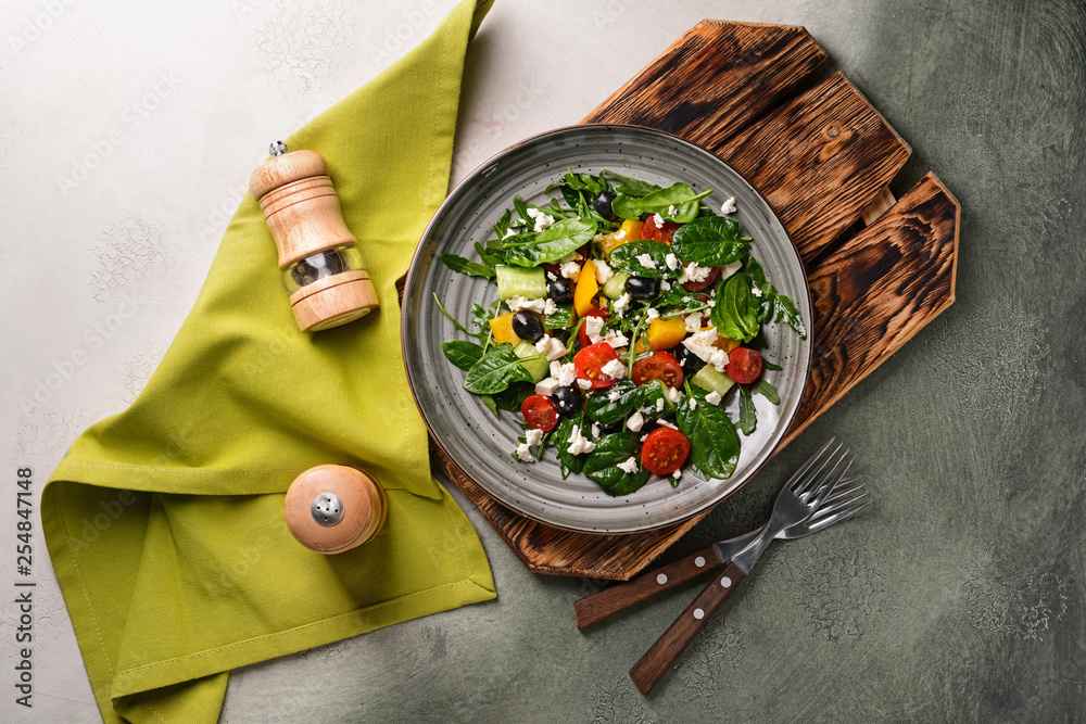 Healthy salad with feta cheese on grey table