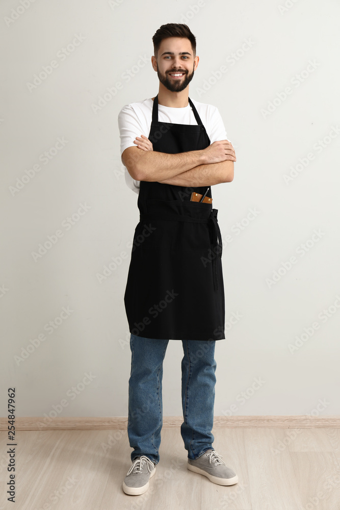 Handsome waiter near light wall